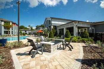 A patio with chairs and a table next to a swimming pool